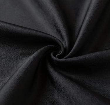 Macro detail of high-quality black silk texture draped elegantly. The lighting is soft but dramatic, emphasizing the craftsmanship and luxury of the material. Minimalist aesthetic following the #0F0F0F and #333333 color scheme.