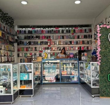 Interior de una tienda de reparación de celulares con estanterías de fundas coloridas y vitrinas de 