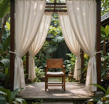 A serene outdoor reflexology area in a garden in Bandung, West Java. A stone pathway leads to a wooden chair surrounded by tropical plants and soft cream-colored curtains swaying in the breeze.