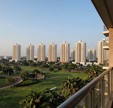 A breathtaking daytime view from a high-floor balcony of a luxury apartment in Greater Noida. The scene captures lush landscaped green parks below and a skyline of modern residential skyscrapers under a clear light blue sky. South Asian urban setting.