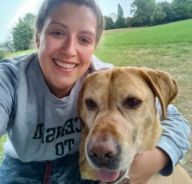 a woman is smiling and holding a dog
