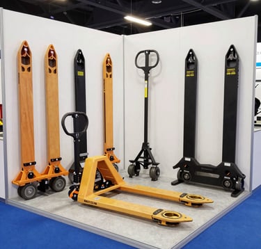 Wide-angle view of an international exhibition hall during a B2B trade show. Professional lighting, premium booths, industrial displays of lifting equipment. Futuristic vibe with #1A1A1A and #FF8E3C highlights.