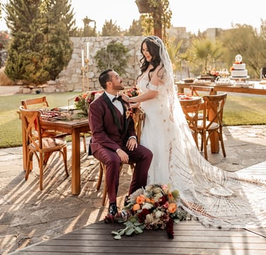 a bride and groom sitting on a chair in a wedding ceremony