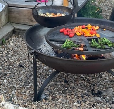 Fire-pit with swing arm BBQ inin a outside seating area as part of outdoor living garden design 