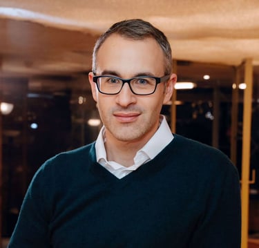 a man in a black sweater and glasses