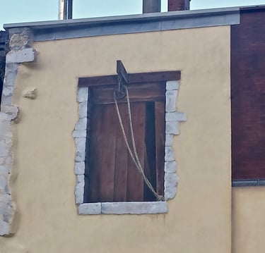 Fenêtre d'atelier peinte en trompe-l'oeil sur une façade à Moirans-en-Montagne dans le Jura, 39.