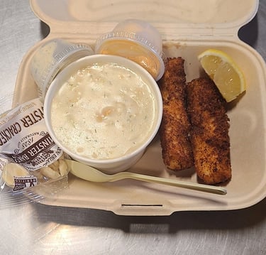 Two pieces of fish with clam chowder, crackers lemon, and sauces in a takeout container from Captain's Galley