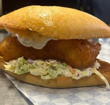 Fried fish sandwich with coleslaw and tartar sauce on a toasted bun from Captain’s Galley