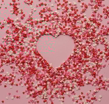 Sur fond rose, coeur représenté par des pailletes coeur roses, rouges et blanches