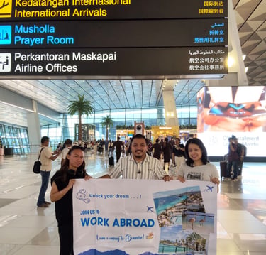 Crew holding AKA banner at an international airport 