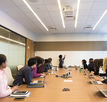 A professional trainer explaining Jira test management to a focused group in a modern conference room.