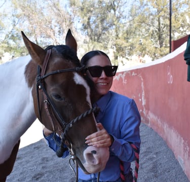 a woman in sunglasses and sunglasses is holding a horse
