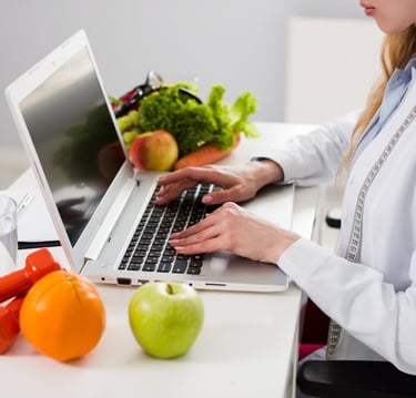 a woman in a lab coat is typing on her laptop