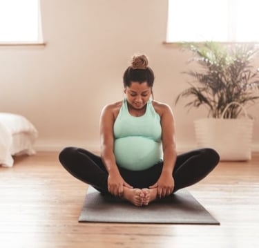 a pregnant woman sitting on a yoga mat
