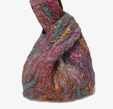 Handmade multi-colored felted wool knot bag with textured fiber art design and earthy tones.