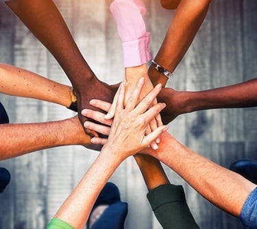 a group of people of different ethnical background holding hands together in a circle
