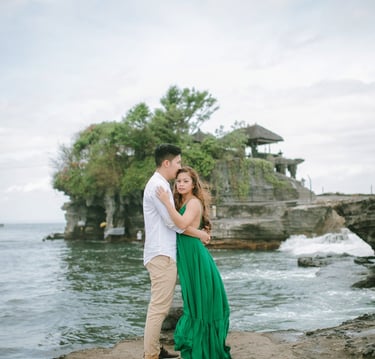 Romantic couple embracing near the ocean cliffs at Tanah Lot Bali.
