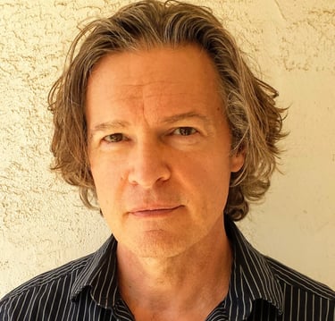 Todd Long with medium-length hair and serious expression