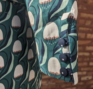 Covered buttons of a green art nouveau 50's inspired cropped jacket