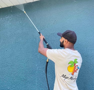 Mop Monkeys technician pressure washing stucco house in Calgary 