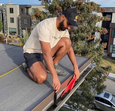 Mop Monkey technician cleaning gutters in Calgary from roof with specialty tools