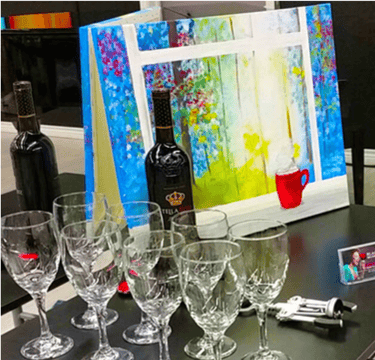 a table with wine glasses and canvas painting