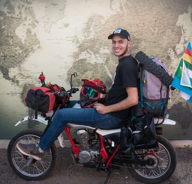 a man sitting on a motorcycle with a backpack on it