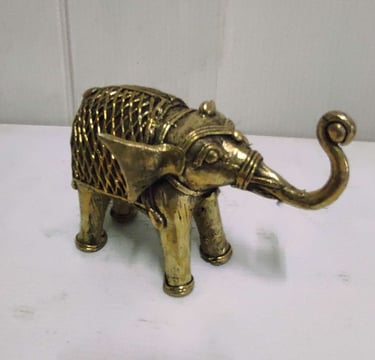 "Finely crafted brass baby elephant with raised trunk and ornate tribal motifs-For global distribution"