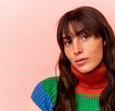 a woman with long hair and a colorful sweater