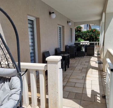 The photo shows the balcony of the apartment with a dining set. 