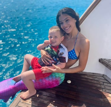 Friendly mermaid sharing a calm moment with a toddler on a family boat cruise