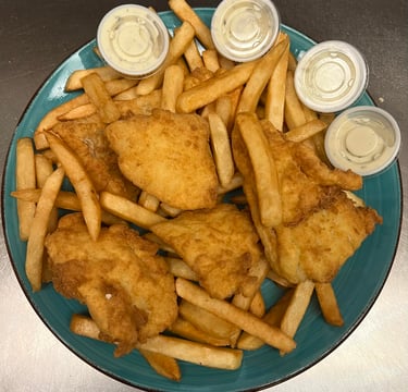 Golden crispy fried fish fillets served with French fries and four cups of tartar sauce on a blue plate.