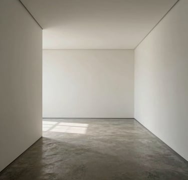 A full-width, high-angle photograph of a minimalist gallery interior in a Global / Contemporary Art context. The composition features stark architectural lines, off-white walls, and soft gray concrete floors. Natural light spills across the space, creating subtle, long shadows. The style is editorial and contemplative, focusing on the calm and organized structure of the room.
