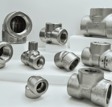 Various stainless steel threaded pipe fittings including tees and elbows for industrial plumbing.