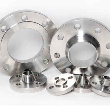 Industrial stainless steel pipe flanges in various sizes for plumbing and oil and gas applications.