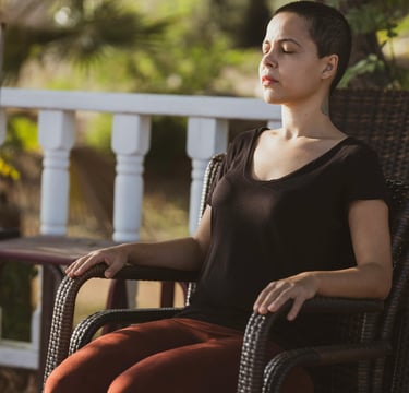 a woman sitting on a chair with her eyes closed
