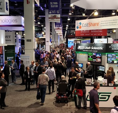 Tradeshow expo hall filled with exhibit booths and attendees.
