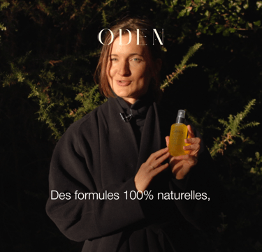 a woman in a black coat and a cosmetic bottle