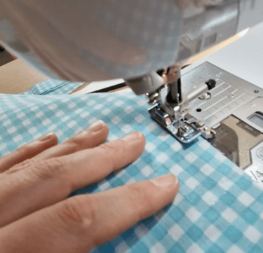 a person sewinging a piece of cloth