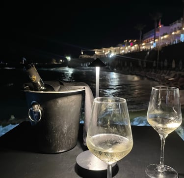 two wine glasses with champagne in front of a boat