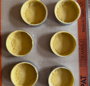 a baking tray with four cups of food and a measuring scale