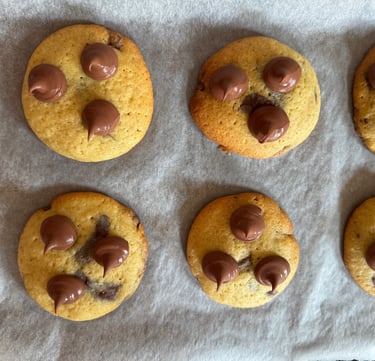 a bunch of chocolate chip cookies on a baking sheet