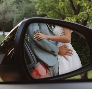 Hochzeitsfotograf Coburg: Kreative Spiegelung des Brautpaars im Außenspiegel eines Audi.