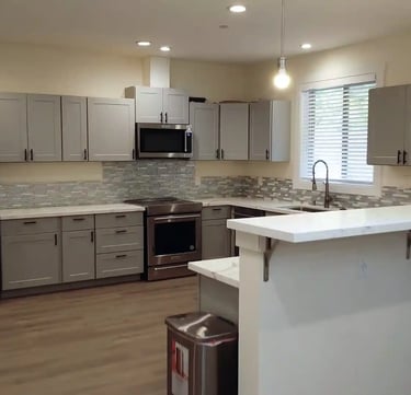 Home-style kitchen in adult family home with stove, refrigerator, and meal preparation space.