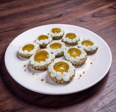 Mini tartas de frutas con glaseado de crema batida y glaseado de albaricoque en un plato blanco sobr