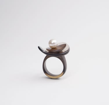 Handcrafted horn ring with a white pearl accent on a minimalist sculptural setting.