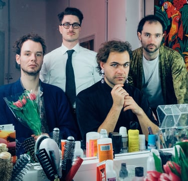 a group of men standing around a table with a bunch of hair
