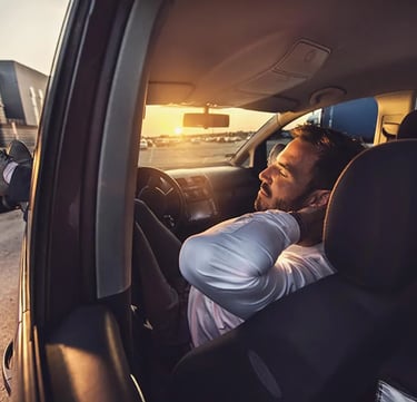 Relaxed car driver with closed eyes chilling in his vehicle
