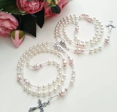 a bunch of pearls and a cross on a table