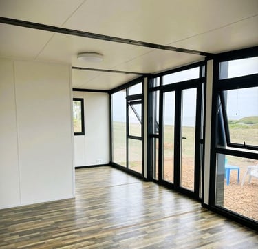 Maison container moderne avec grande façade vitrée lumineuse.